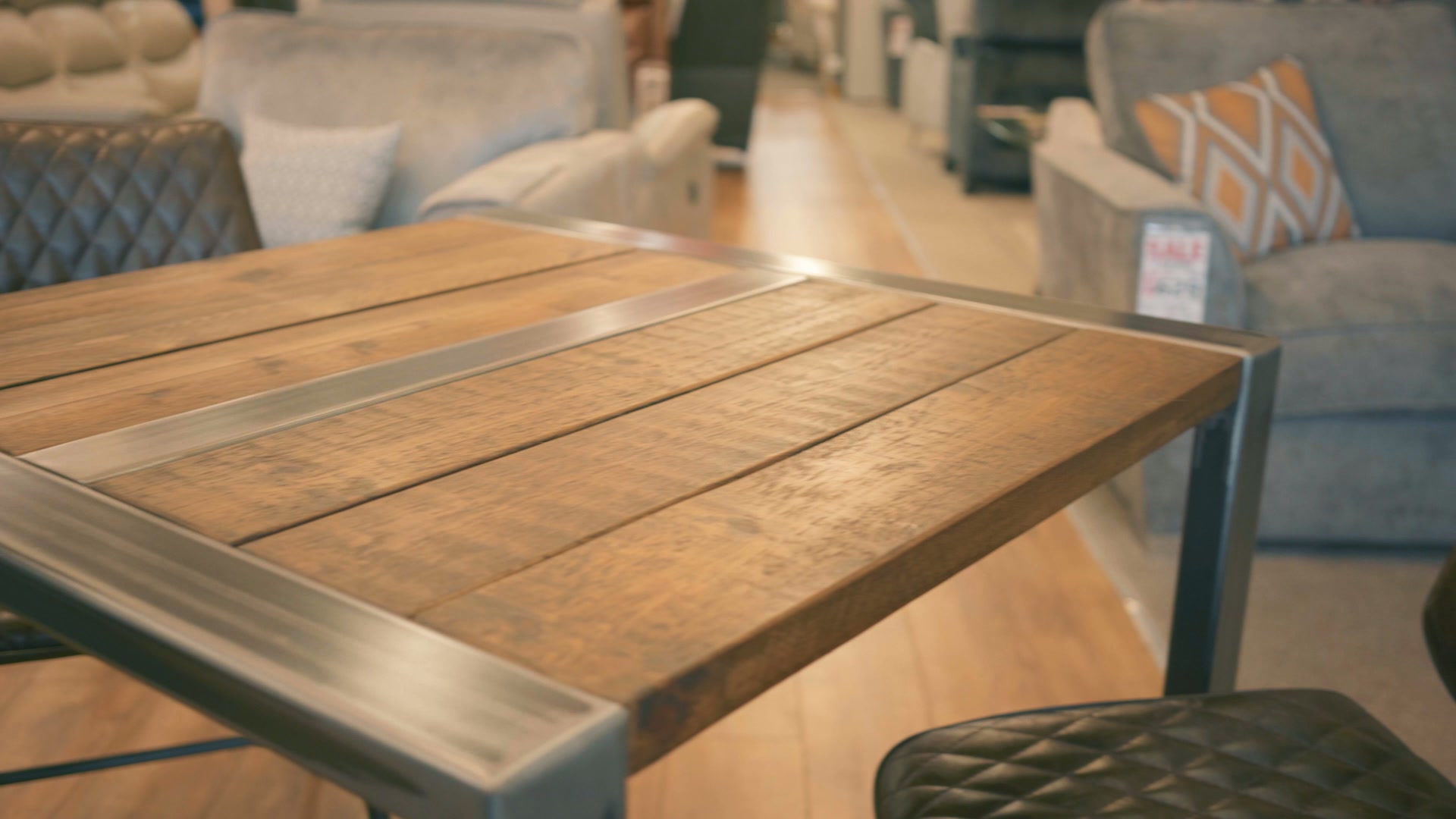 Warm wooden tabletop detail with upholstered furniture in the Lords Furniture promotional film