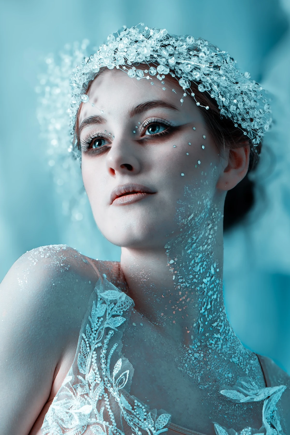 Close beauty portrait in pale blue light with a decorative crystal headpiece